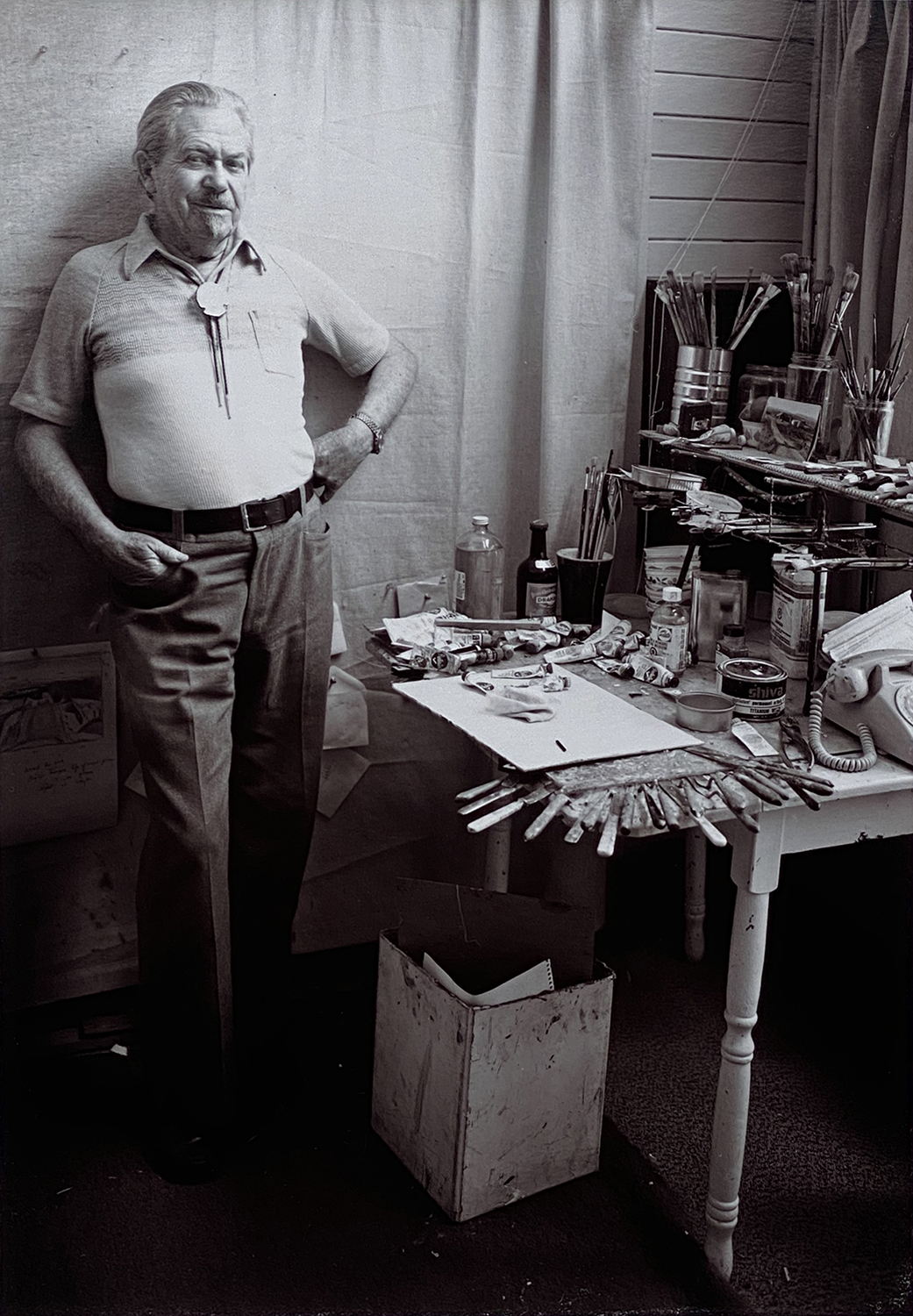 Black and white photograph of Illingworth Kerr standing in his art studio; photograph by Harry Palmer